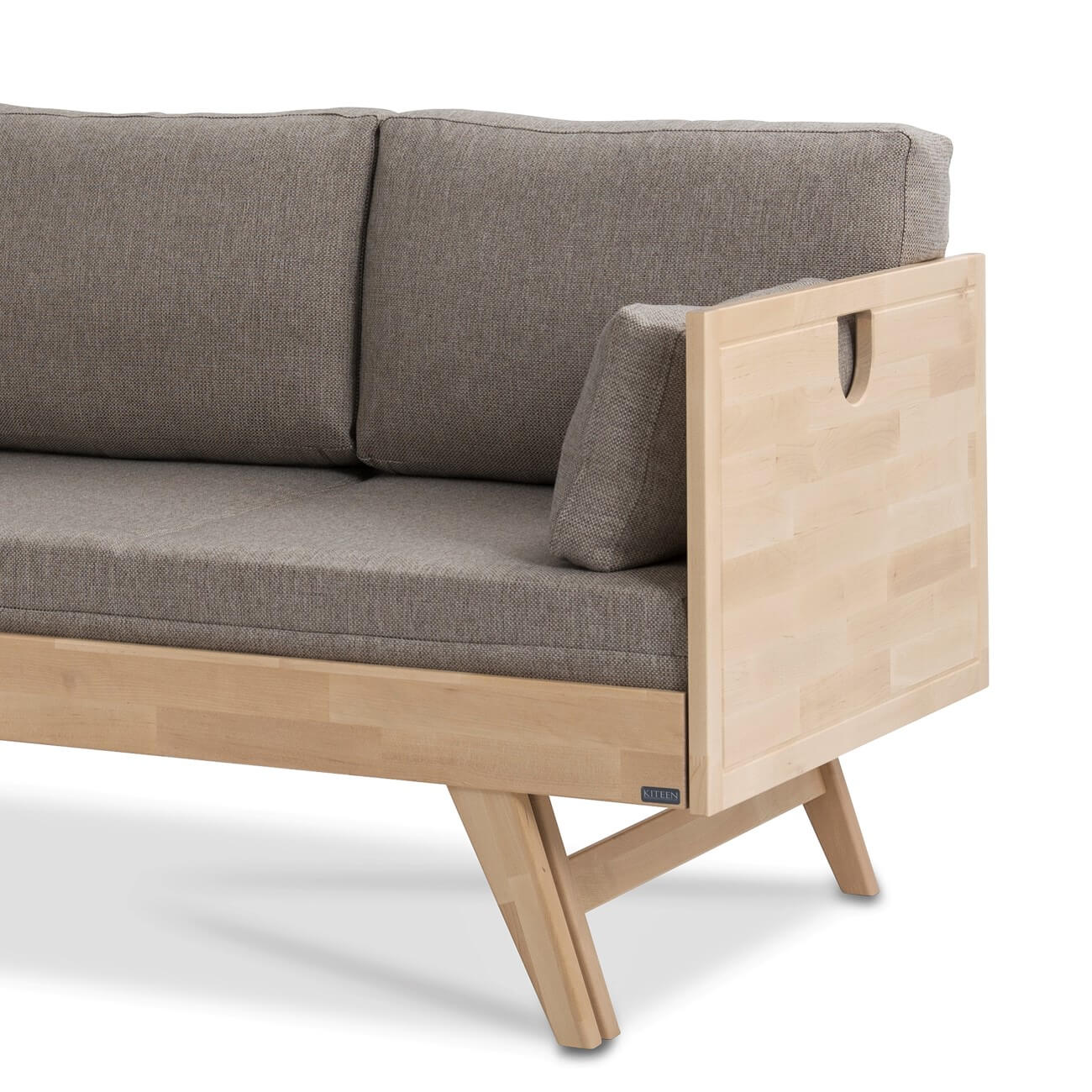 Sofa drewniana NOTTE z brzozy skandynawskiej z funkcją spania. Fragment z drewnianym bokiem i wysokimi nogami. Widoczny beżowy materac i 3 poduszki. Nowoczesny minimalistyczny styl