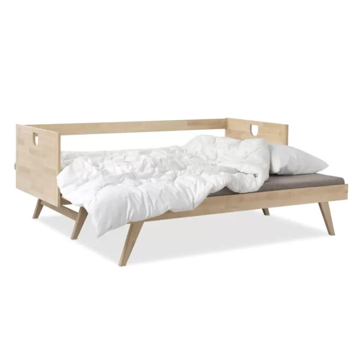 Rozłożona nowoczesna sofa drewniana NOTTE z beżowym materacem i pościelą. Sofa z funkcją spania na wysokich nogach z brzozy skandynawskiej