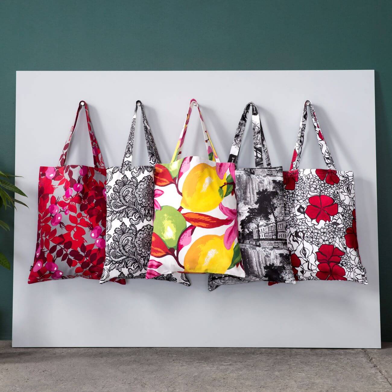 Bawełniane kolorowe torby skandynawskie w aranżacji w studiu firmy Vallila. Torby na zakupy przywieszone na ścianie widoczne w całości. Skandynawski design