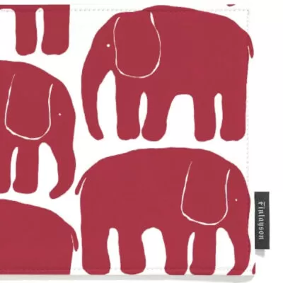 Czerwone łapki kuchenne ELEFANTTI. Na białym tle powtarzający się uproszczony graficzny wzór w czerwone słonie. Widoczny fragment łapki do kuchni z logo producenta. Skandynawski nowoczesny design