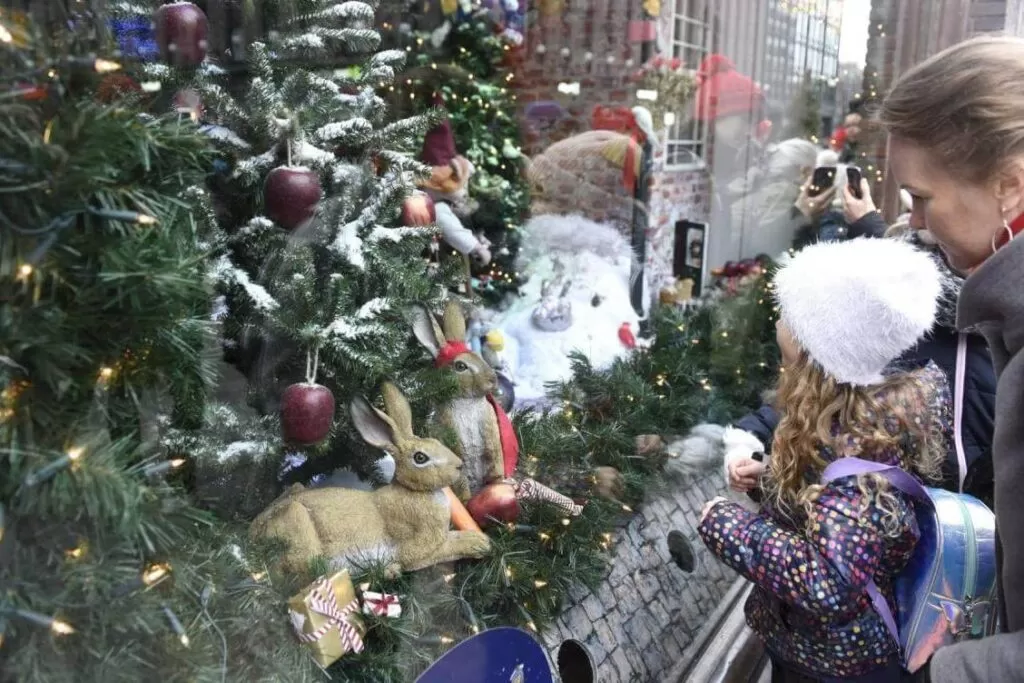 Świąteczna wystawa w Finalndii. dzieci oglądające króliki, choinki i inne elementy wystawy sklepowej bozonarodzeniowej.
