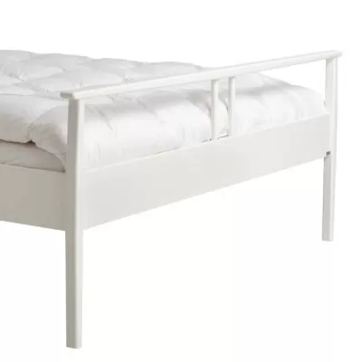 Białe łóżko drewniane nowoczesne NOEL do sypialni. Fragment z widokiem na piękne wysokie nóżki łóżka 160x200 z drewna brzozy skandynawskiej lakierowanej na biało