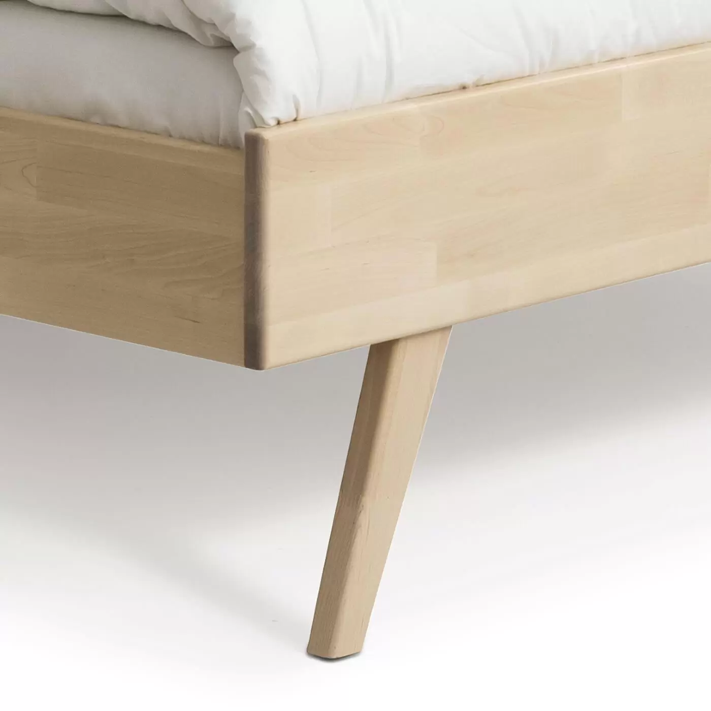 Łóżko drewniane 160x200 NOTTE. Przybliżony widok wysokiej skośnej nóżki łóżka 160x200 z litego drewna brzozy skandynawskiej. Nowoczesny design