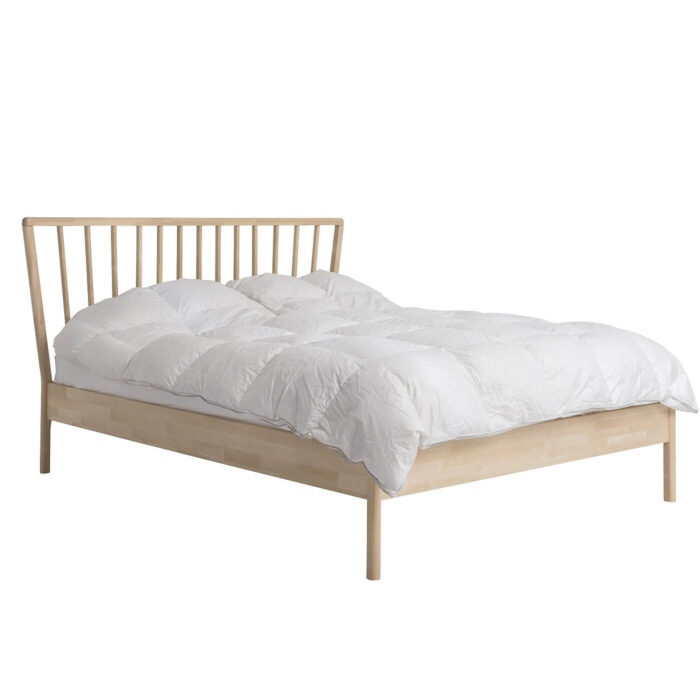 Łóżko skandynawskie MELODIA. Widoczne w całości łóżko drewniane do sypialni 160x200. Na łóżku ze szczytem ażurowym z drewna brzozy skandynawskiej leżąca biała kołdra