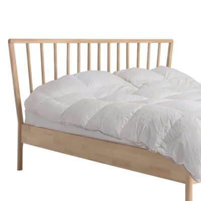 Łóżko skandynawskie MELODIA. Fragment łóżka 160x200 z drewnianym wysokim ażurowym szczytem i leżącą białą kołdrą. Nowoczesny design