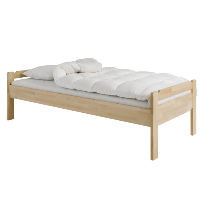 Łóżko z niskim zagłówkiem KUUSAMO z materacem 90x200, odchyloną białą kołdrą i poduszką. Łóżko na wysokich prostych nóżkach z litego drewna brzozy skandynawskiej widoczne w całości