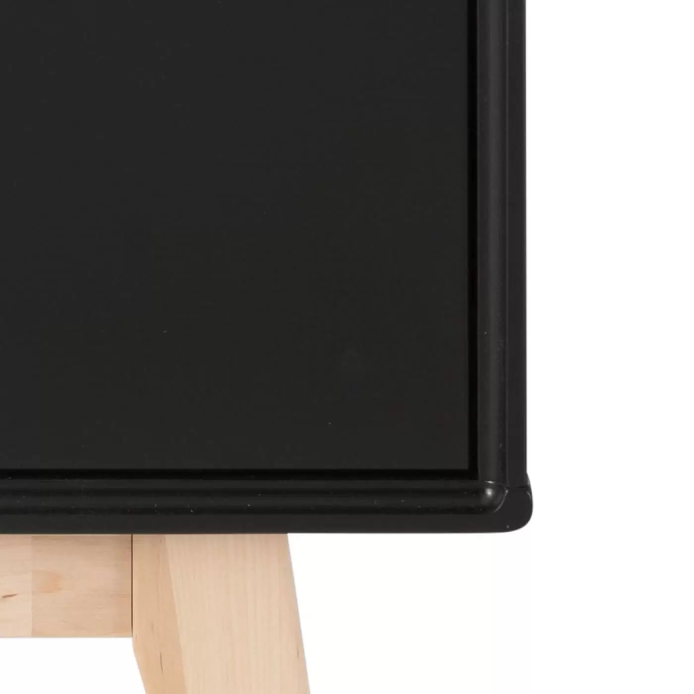 Szafka nocna z szufladami KOLO. Fragment rogu nowoczesnego czarnego mebla z litego drewna brzozy skandynawskiej ręcznie robionego