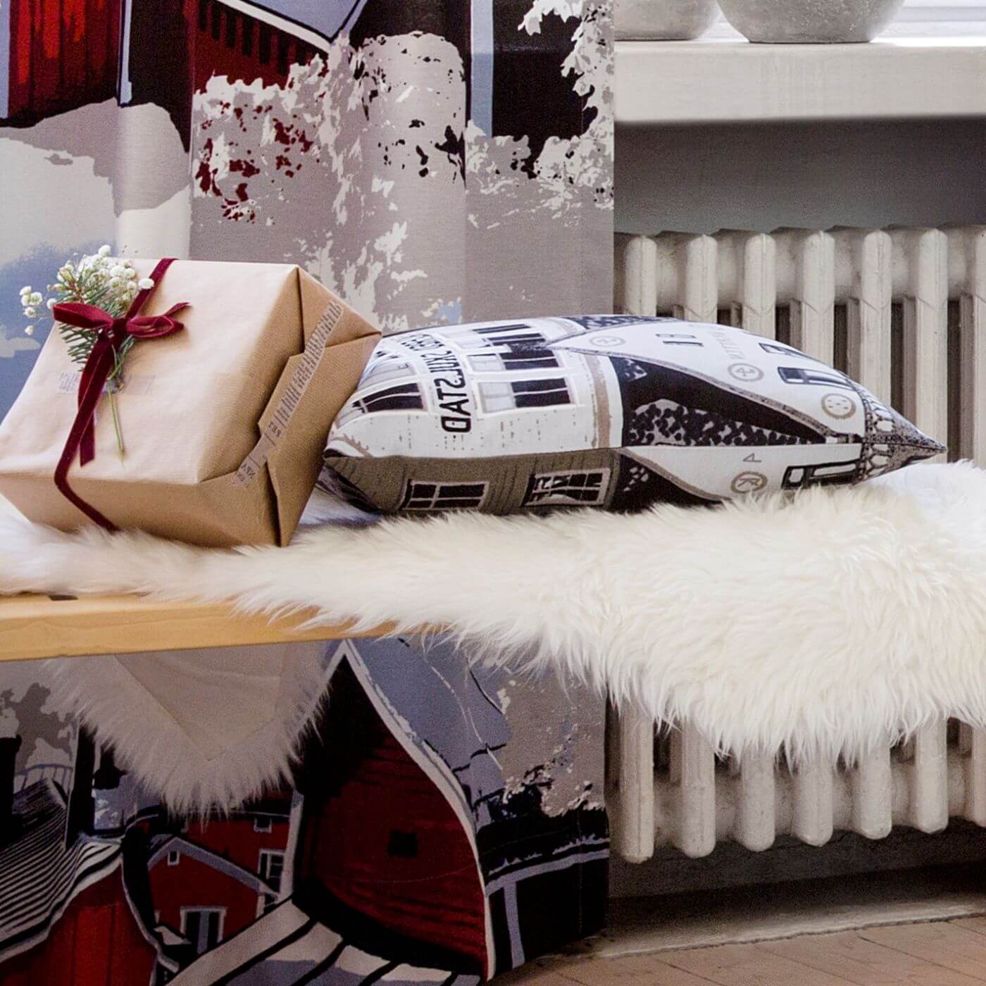Poszewka dekoracyjna skandynawskie domy BERGEN na poduszkę brązowo szara. Zbliżenie świątecznej aranżacji w skandynawskim salonie