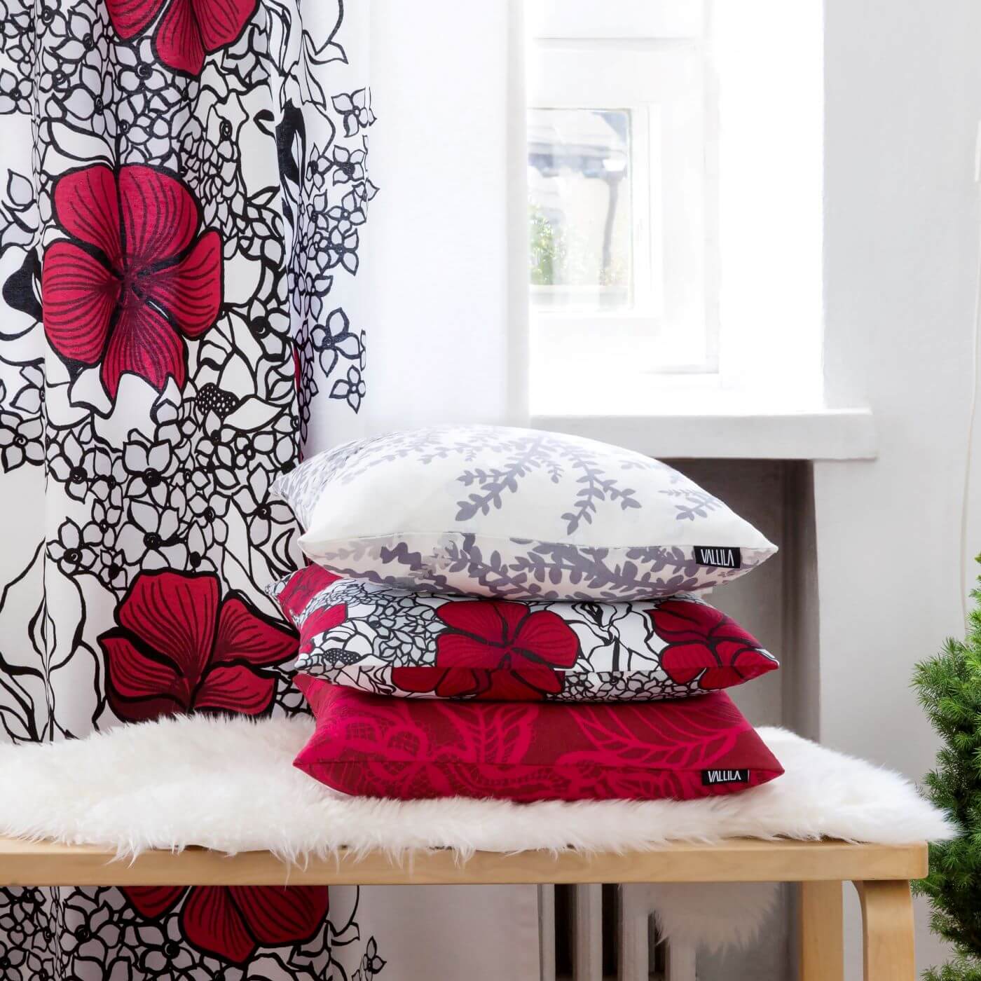 Poduszka dekoracyjna czerwone kwiaty ELLE. Zbliżenie aranżacji bawełnianej poduszki w czerwone i szare kwiaty. Skandynawski świąteczny wystrój salonu