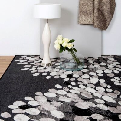 Nowoczesny dywan do salonu SYDÄNPUU. Ciemno szary dywan do nowoczesnego salonu w jasny wzór 3D w aranżacji z białymi różami i białą lampą. Nowoczesne skandynawskie wzornictwo
