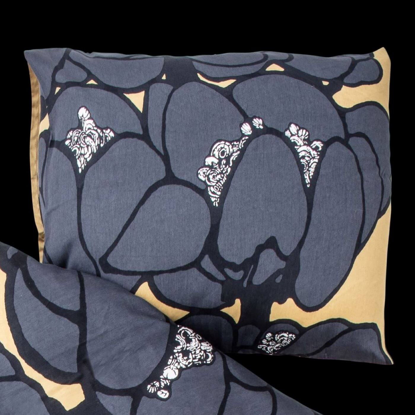 Poszewka elegancka MAKEBA. Bawełniana poszewka na poduszkę w duże szare kwiaty widoczna na czarnym prześcieradle. Nowoczesny skandynawskie design